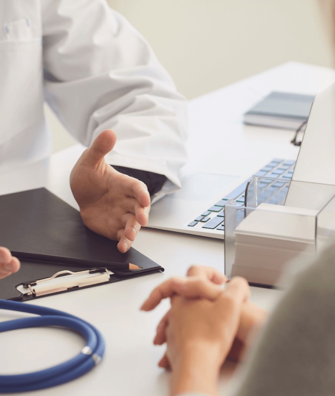 A doctor in consultation with a patient across a desk